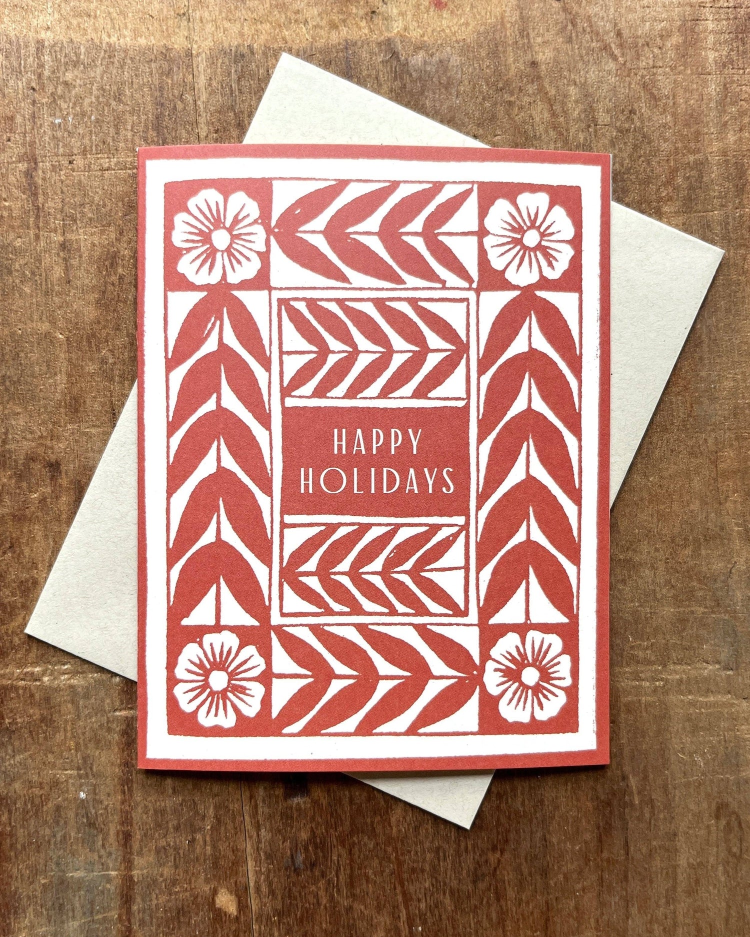 Red and white holiday card with geometric  and floral patterns with text Happy Holidays
